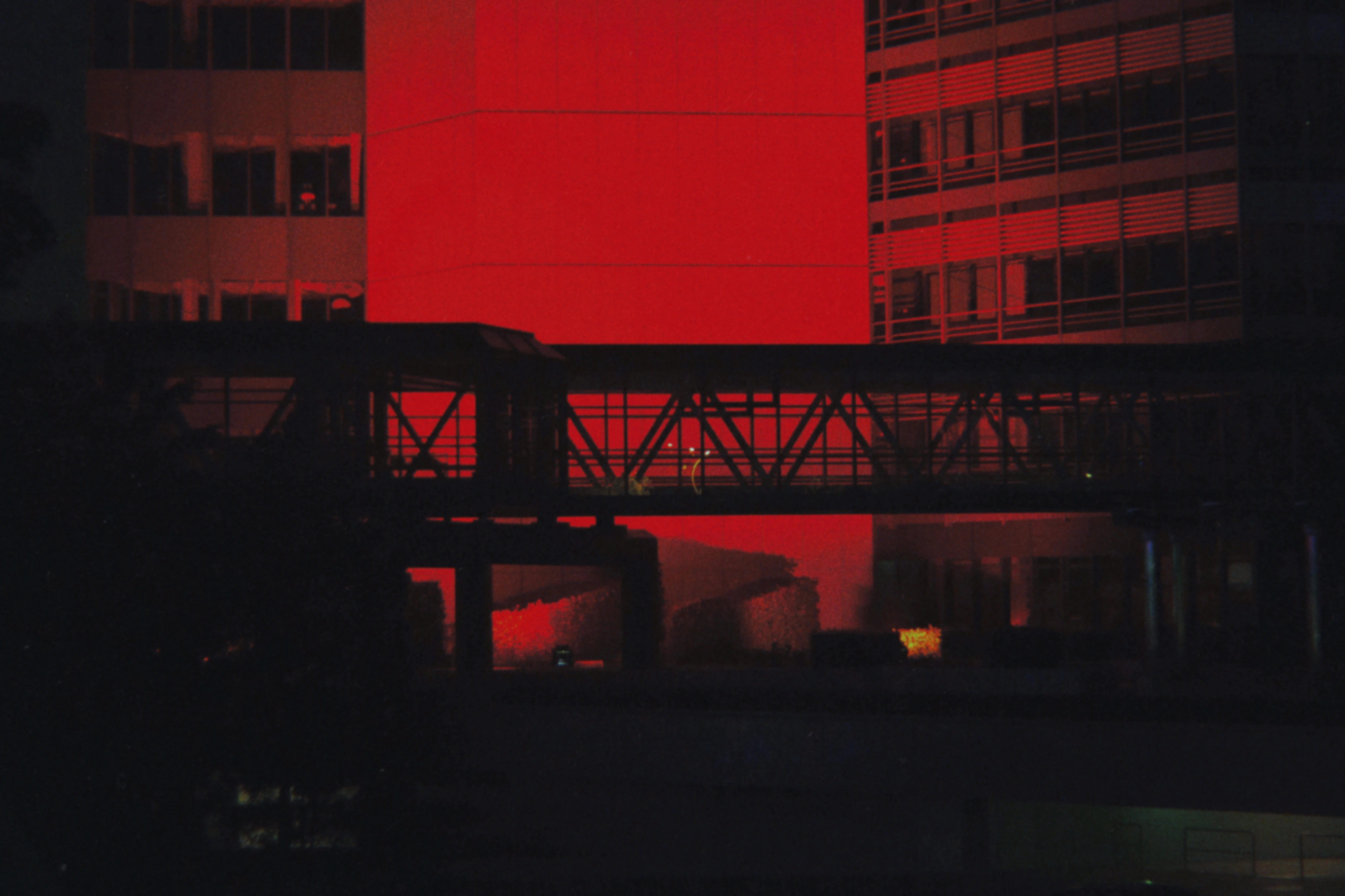 Silhouetted Bridge in front of red-illuminated office building in Hamburg. Shot by Dennis Riebenstahl, DoP.